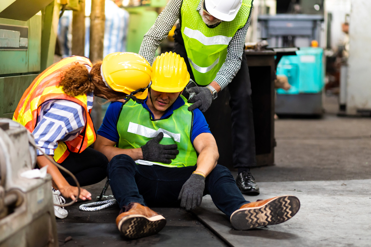 worker on floor after suffering and injury surrounded by other employees